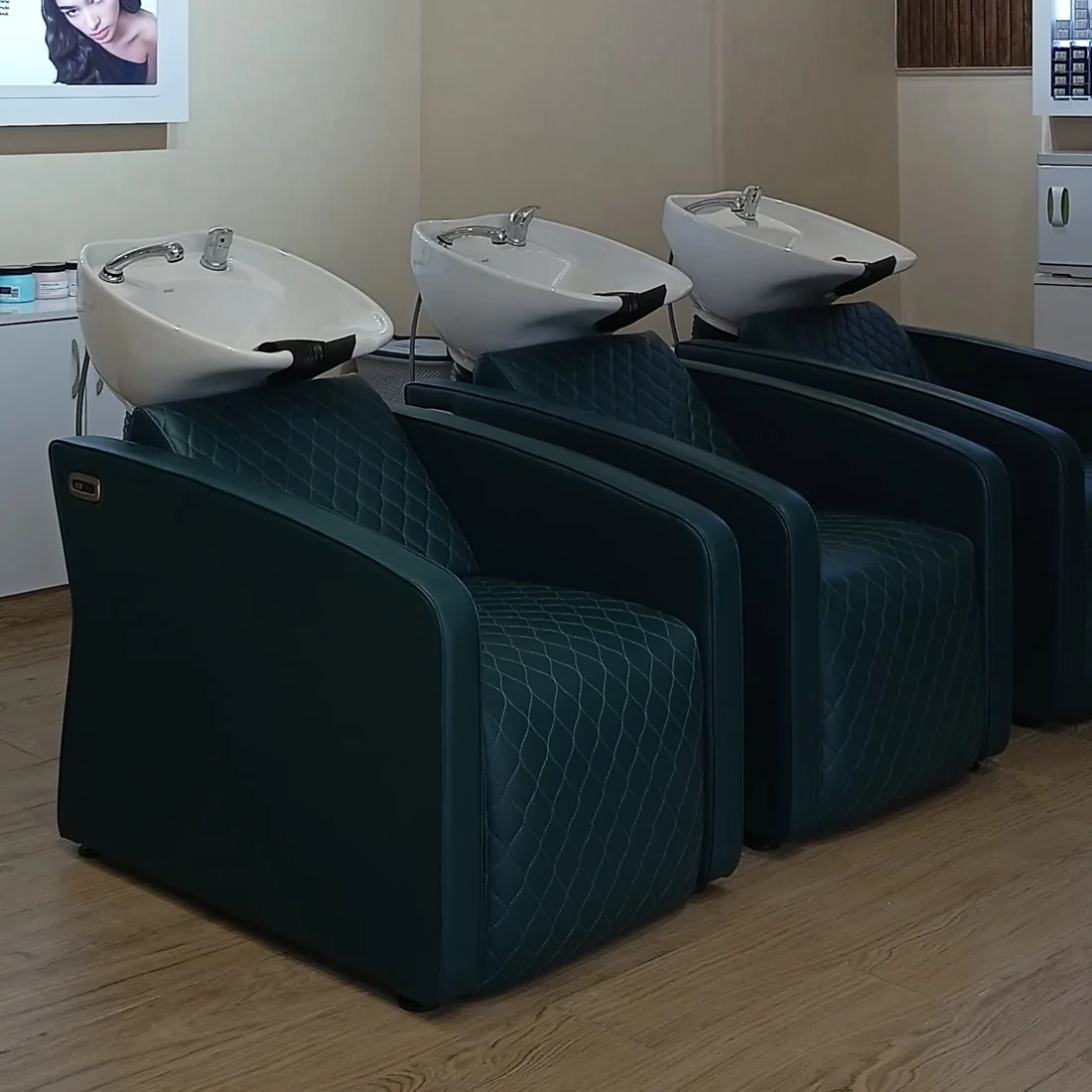 Three wash basins with teal leather chairs